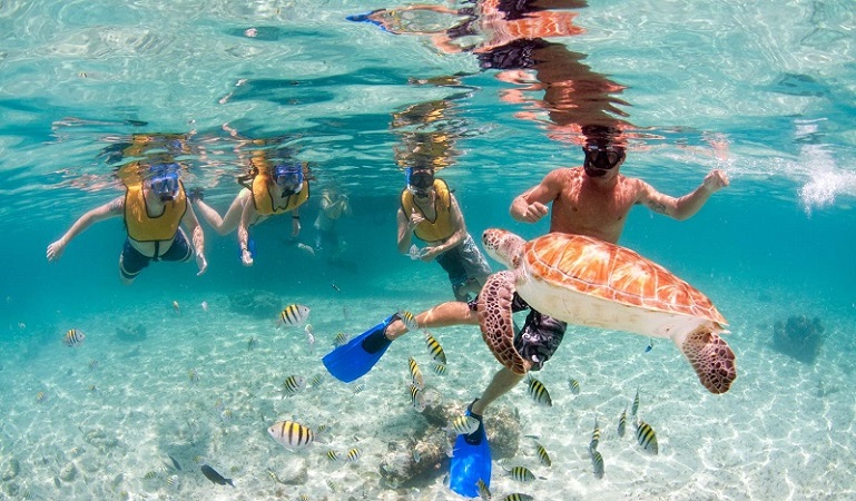 Turistas mergulhando na praia de Punta Cana